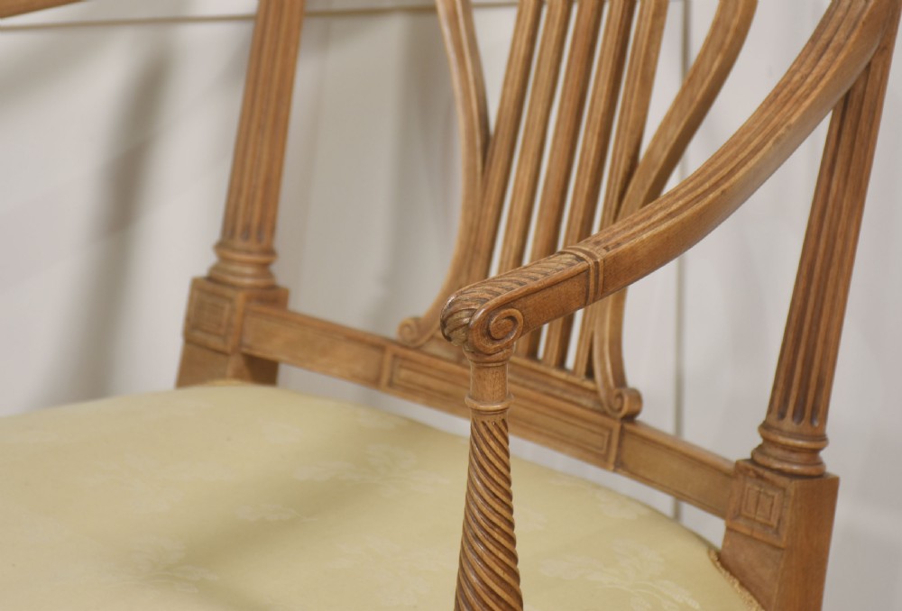 A pair of light mahogany open armchairs featuring lyre-designed back splats, carved rosettes on the top rails, fluted turned legs, and cream-patterned upholstered seats. View VII