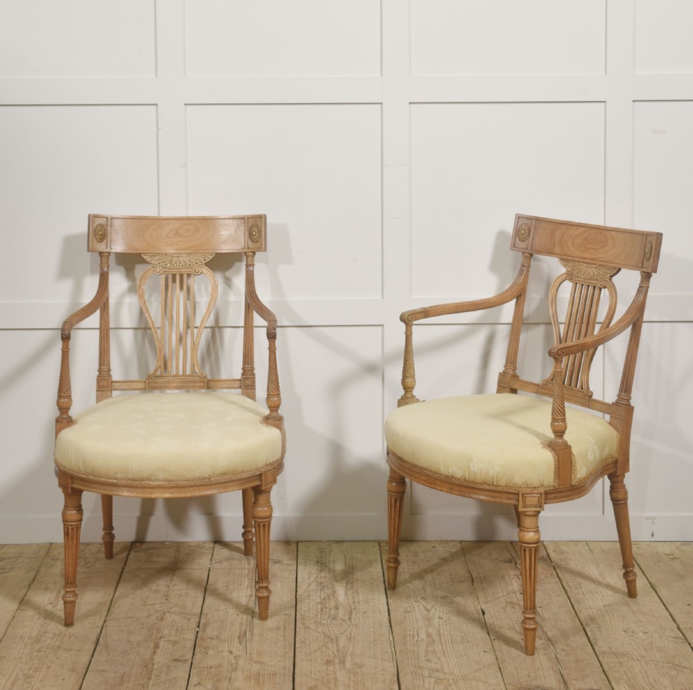 A pair of light mahogany open armchairs featuring lyre-designed back splats, carved rosettes on the top rails, fluted turned legs, and cream-patterned upholstered seats. View VIII