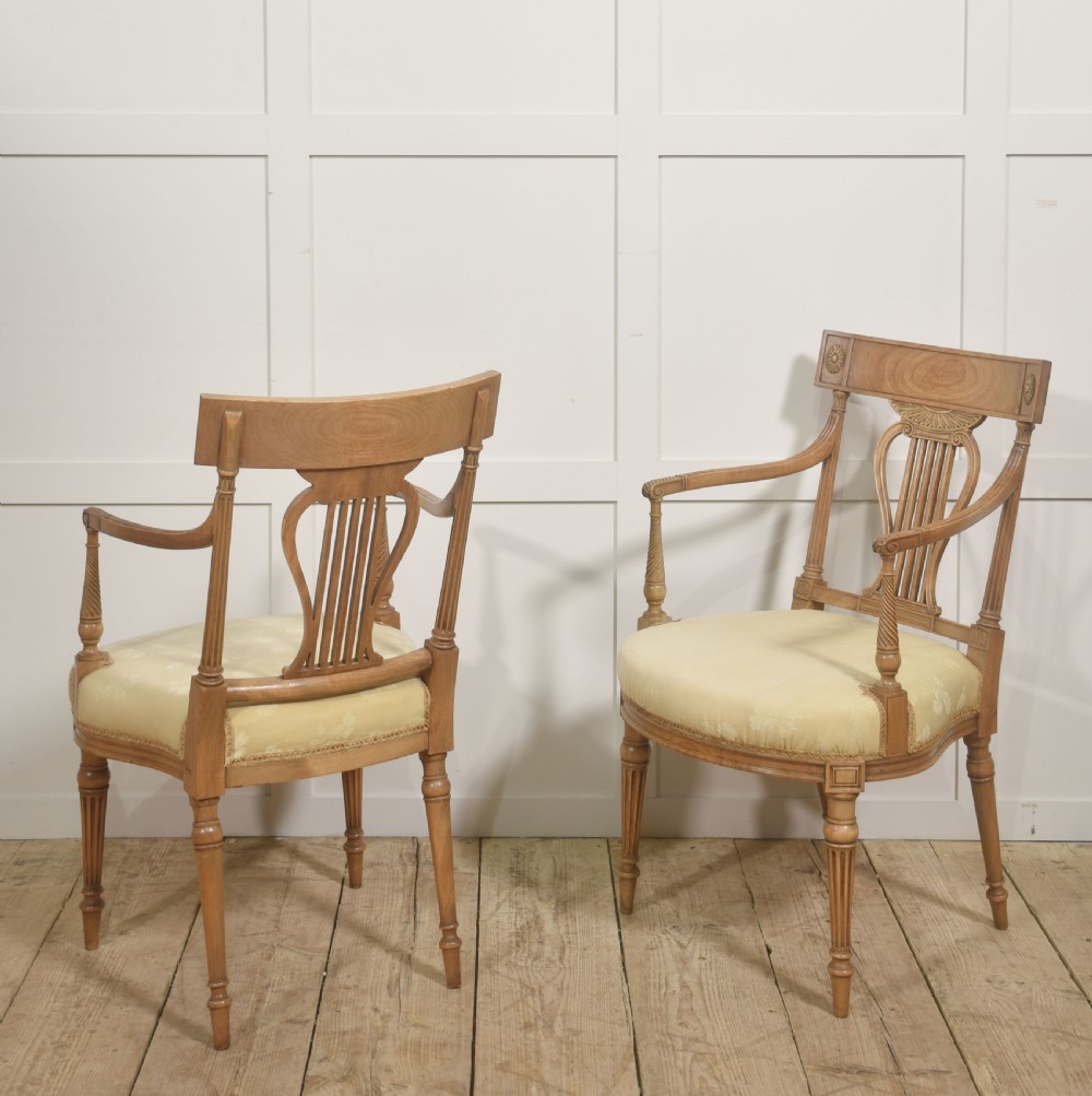 A pair of light mahogany open armchairs featuring lyre-designed back splats, carved rosettes on the top rails, fluted turned legs, and cream-patterned upholstered seats. View IX