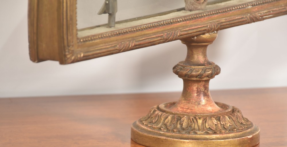 A hand-painted folding fan featuring a pastoral musical scene mounted inside a glazed giltwood frame on a turned pedestal. View V