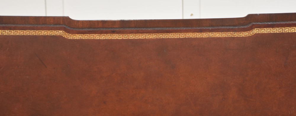 A large mahogany pedestal desk featuring a leather writing surface, multiple drawers with brass swan-neck handles, and carved corner details. View XIX
