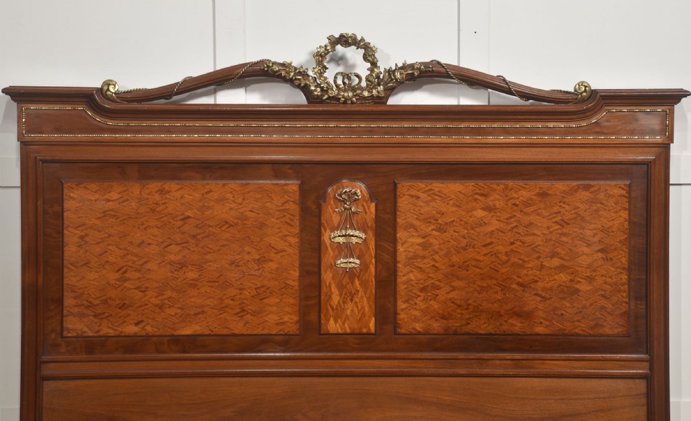 A Louis XVI style mahogany double bed frame featuring decorative parquetry veneer panels and polished gilt bronze mounts. View II