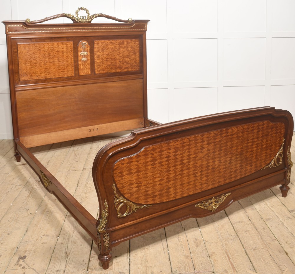 A Louis XVI style mahogany double bed frame featuring decorative parquetry veneer panels and polished gilt bronze mounts. View VIII