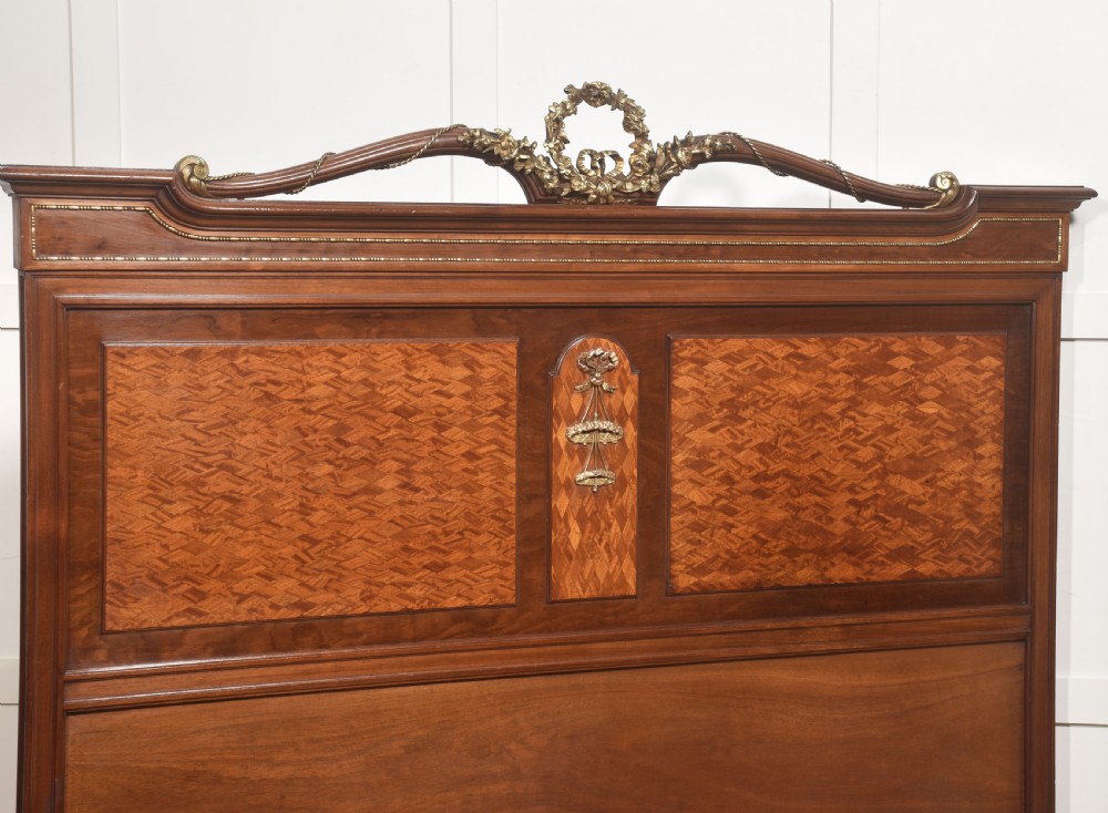 A Louis XVI style mahogany double bed frame featuring decorative parquetry veneer panels and polished gilt bronze mounts. View IX