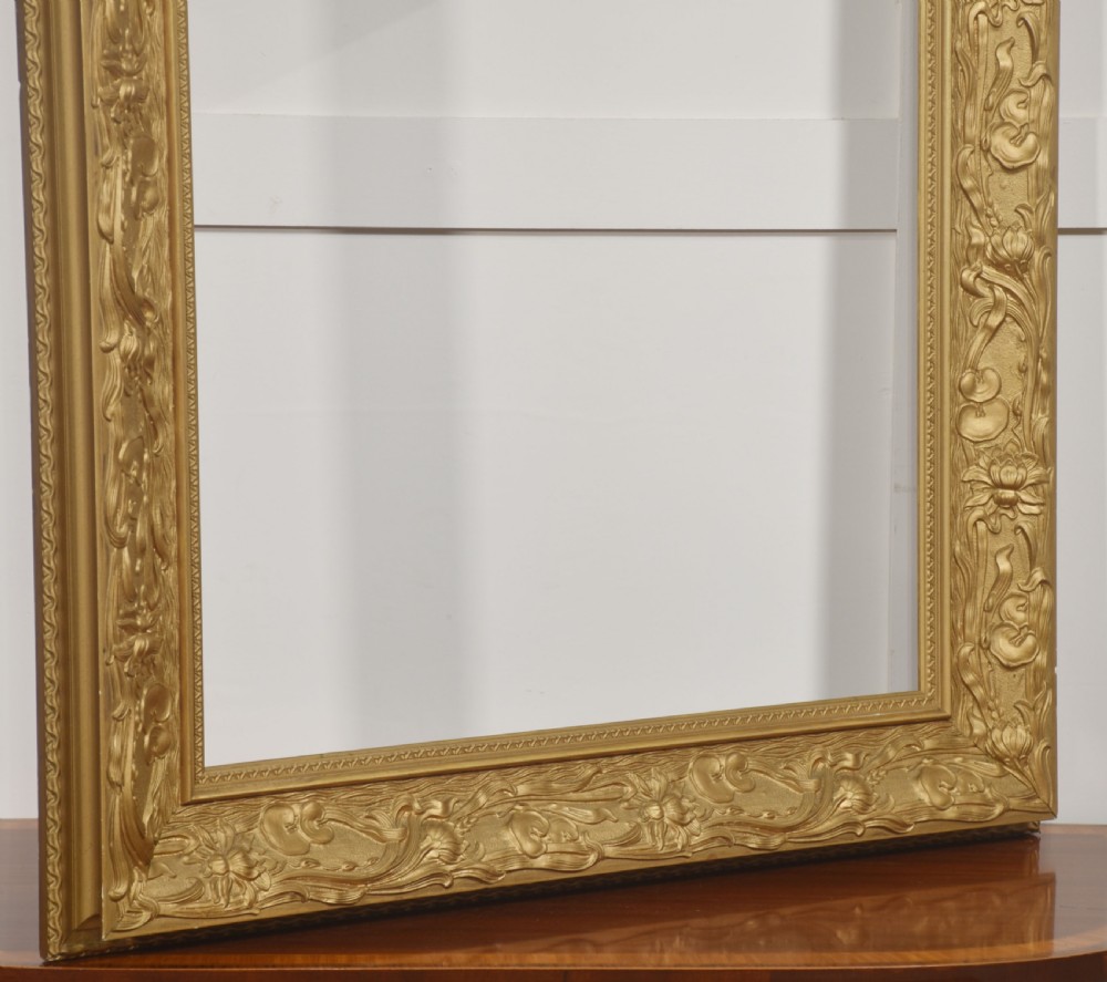 A large rectangular giltwood picture frame featuring deep-relief Art Nouveau floral and botanical carvings along the profile. View VIII