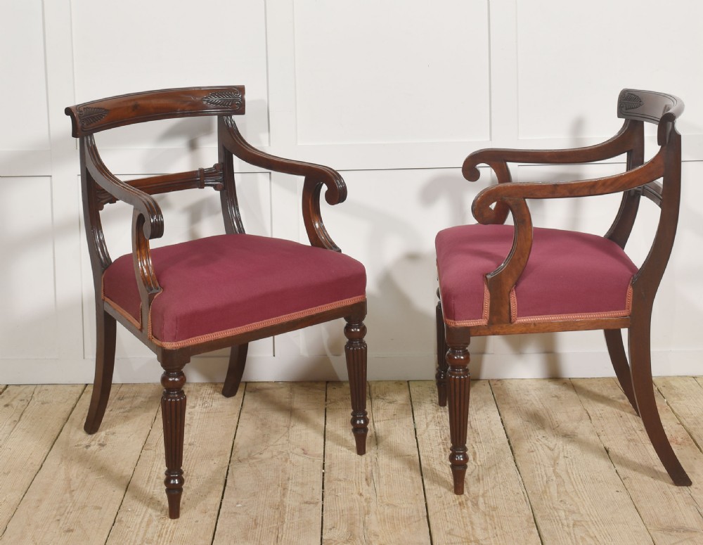 A pair of George IV mahogany armchairs featuring carved curved crest rails, swept arm supports, reeded front legs, and red fabric seats. View VIII