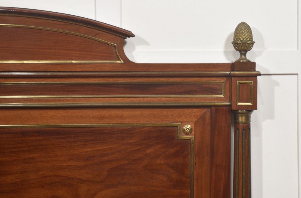 Late nineteenth-century mahogany bedframe featuring brass mouldings, fluted post columns topped with pineapple finials, and raised panel work on the headboard and footboard. View III