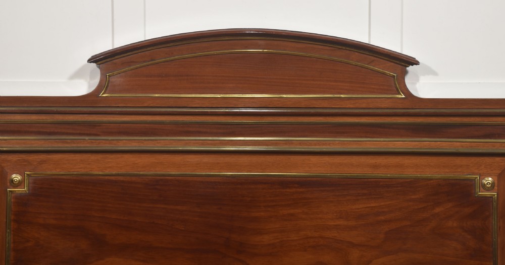Late nineteenth-century mahogany bedframe featuring brass mouldings, fluted post columns topped with pineapple finials, and raised panel work on the headboard and footboard. View IV