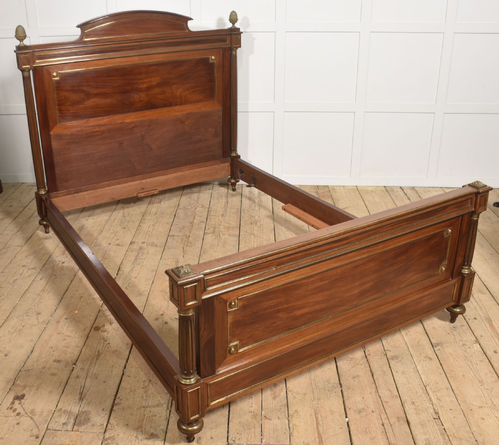 Late nineteenth-century mahogany bedframe featuring brass mouldings, fluted post columns topped with pineapple finials, and raised panel work on the headboard and footboard. View VIII