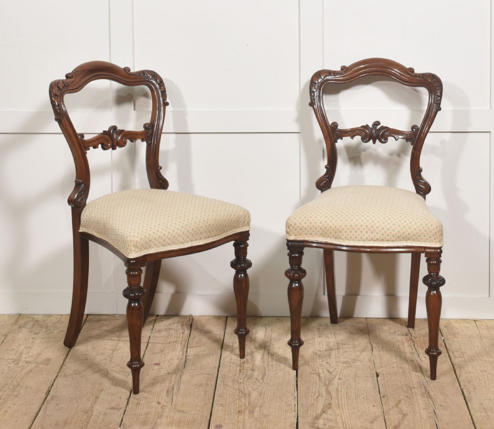 A pair of mid-19th-century rosewood side chairs featuring open balloon backs with carved detail rails, turned front legs, and cream-coloured patterned fabric seats. View III