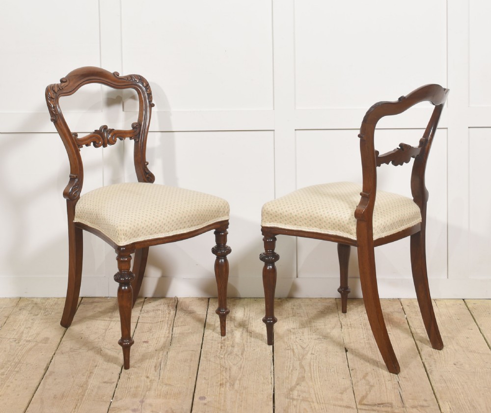 A pair of mid-19th-century rosewood side chairs featuring open balloon backs with carved detail rails, turned front legs, and cream-coloured patterned fabric seats. View IV