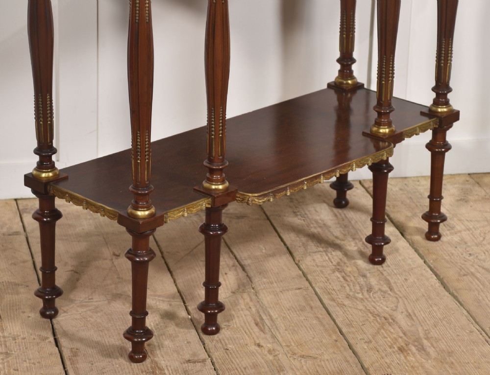 Regency Revival mahogany console table featuring a marble top with a brass gallery, gilt mounts, turned fluted legs, and a lower tier shelf. View IV