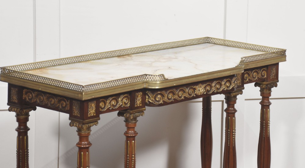 Regency Revival mahogany console table featuring a marble top with a brass gallery, gilt mounts, turned fluted legs, and a lower tier shelf. View V