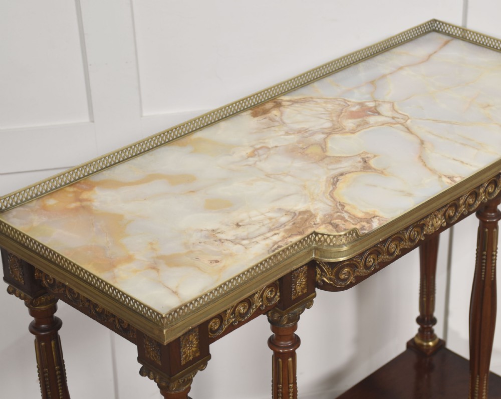 Regency Revival mahogany console table featuring a marble top with a brass gallery, gilt mounts, turned fluted legs, and a lower tier shelf. View VIII