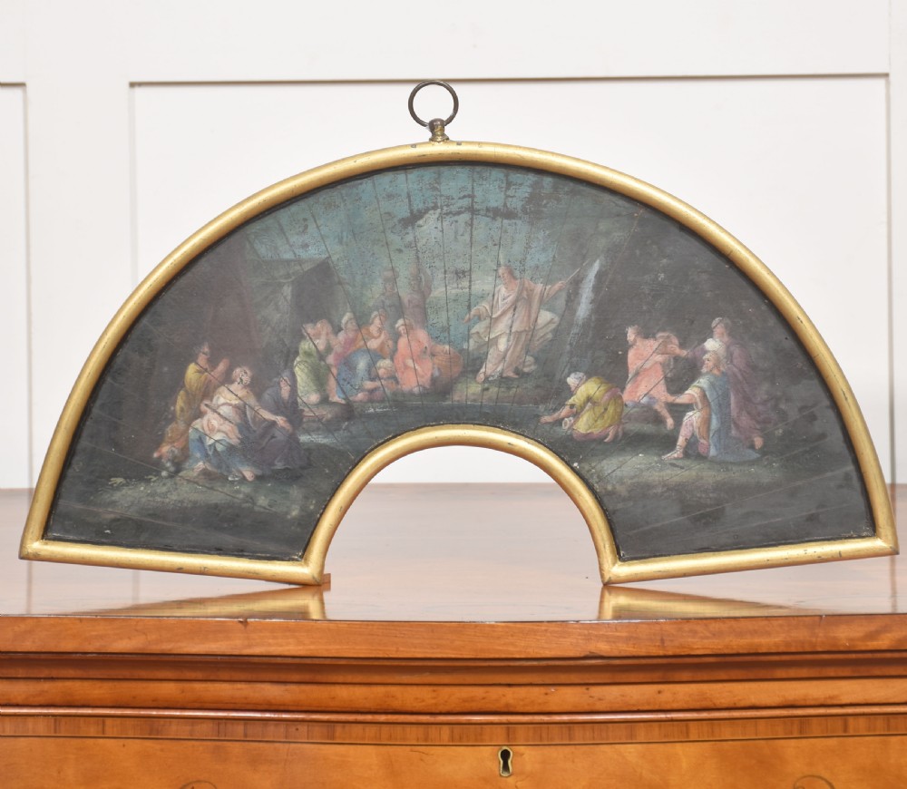 A fan-shaped gilt metal frame containing a hand-painted antique fan leaf depicting a biblical scene with figures in classical drapery. View III