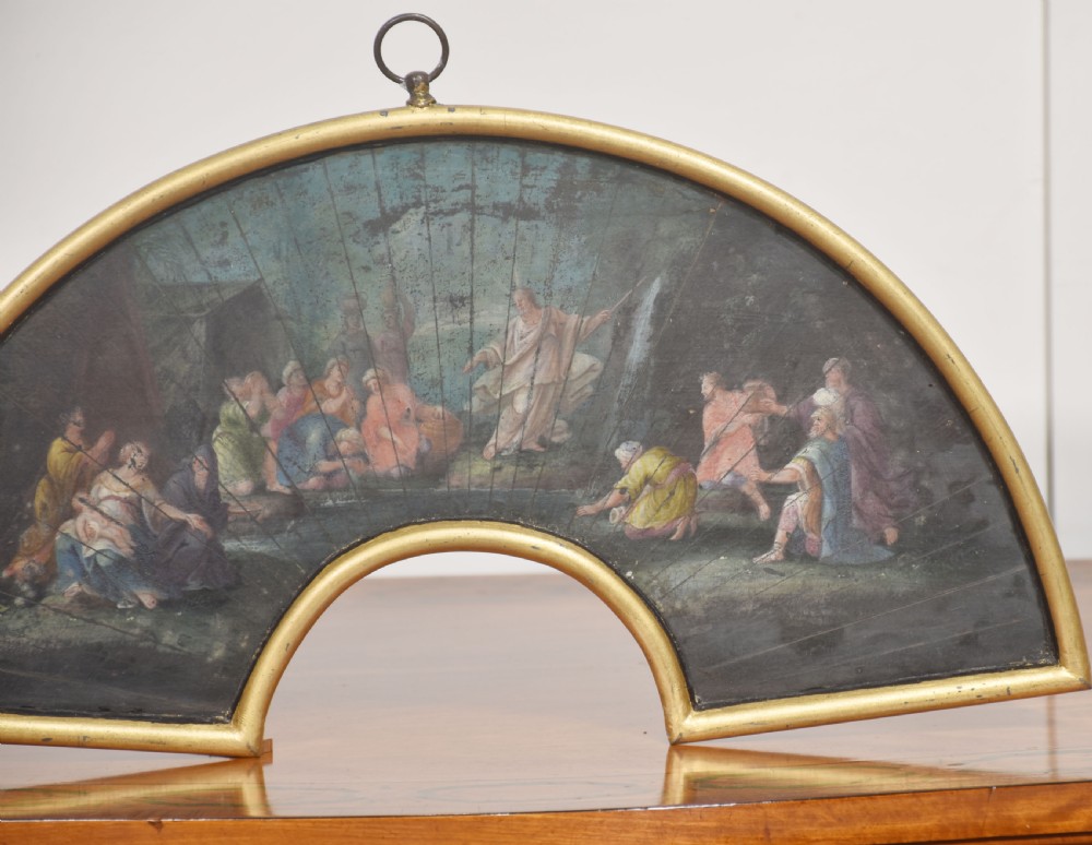 A fan-shaped gilt metal frame containing a hand-painted antique fan leaf depicting a biblical scene with figures in classical drapery. View IV
