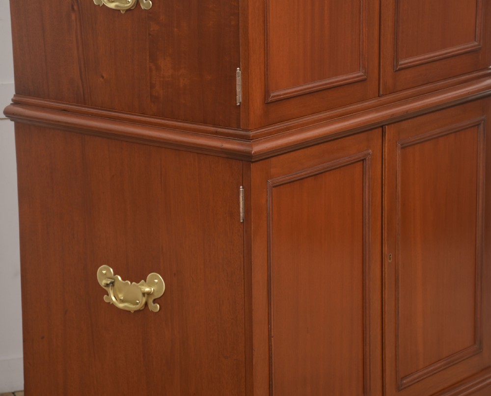 A two-section mahogany collectors cabinet featuring double doors that open to reveal stacked drawers with flush brass handles. View II