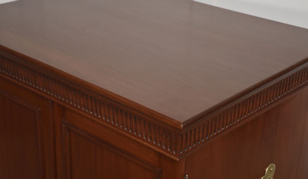 A two-section mahogany collectors cabinet featuring double doors that open to reveal stacked drawers with flush brass handles. View XII