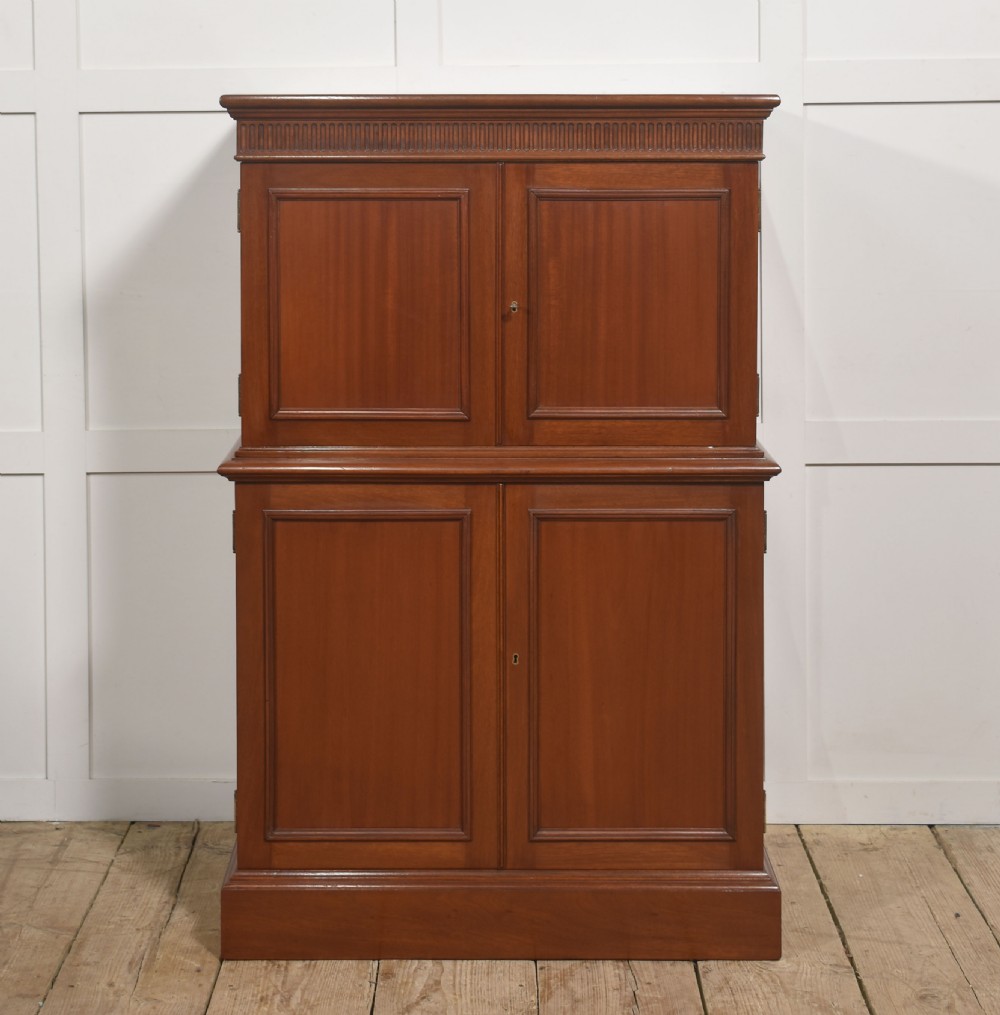 A two-section mahogany collectors cabinet featuring double doors that open to reveal stacked drawers with flush brass handles. View XIII