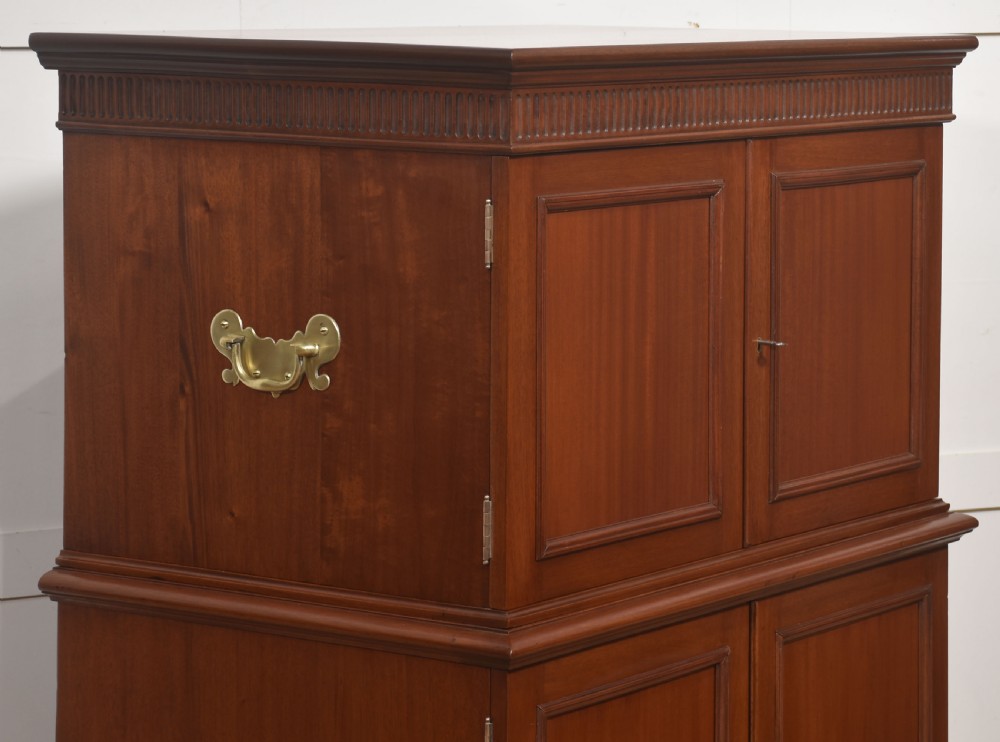 A two-section mahogany collectors cabinet featuring double doors that open to reveal stacked drawers with flush brass handles. View XIV