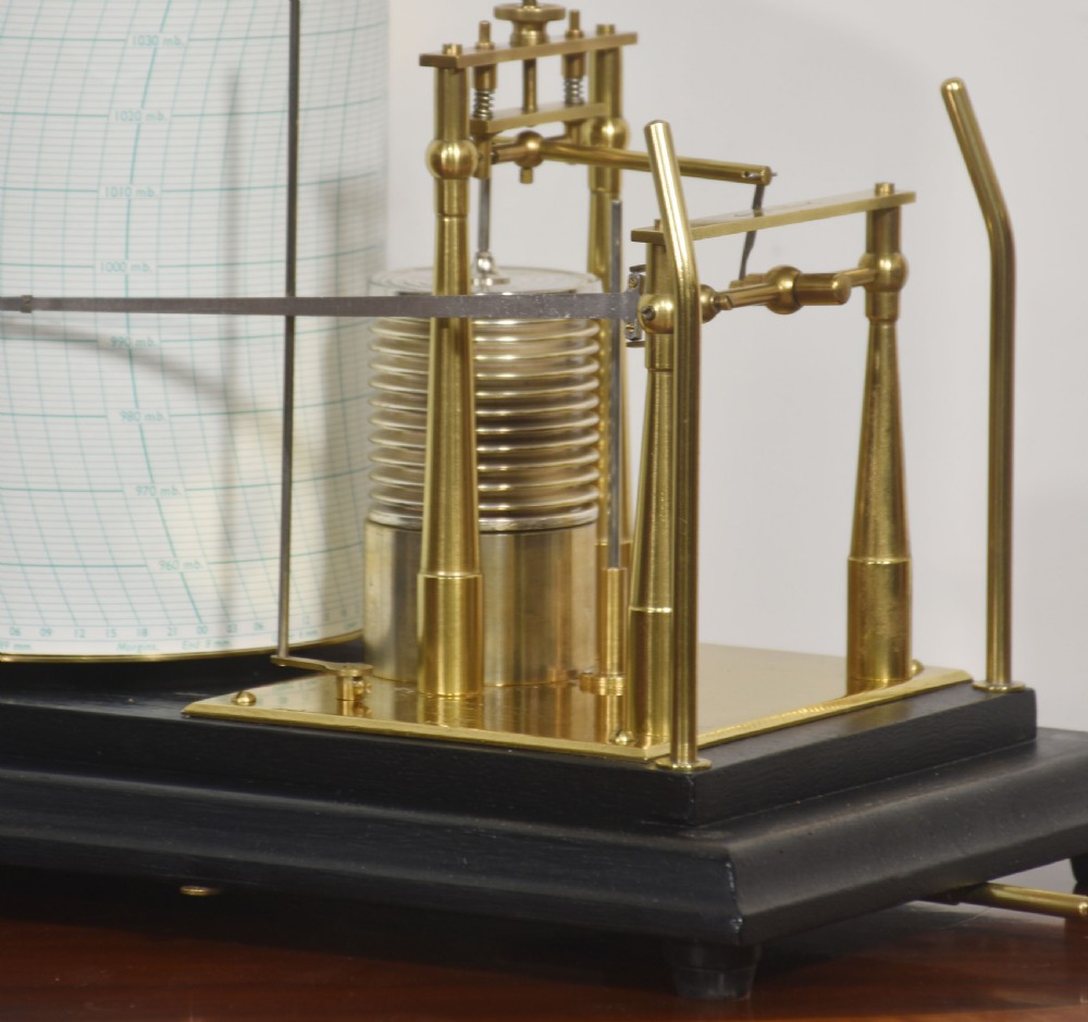 An antique Short and Mason aneroid barograph housed in a black glazed wooden case with brass carrying handles and internal mechanism. View VII