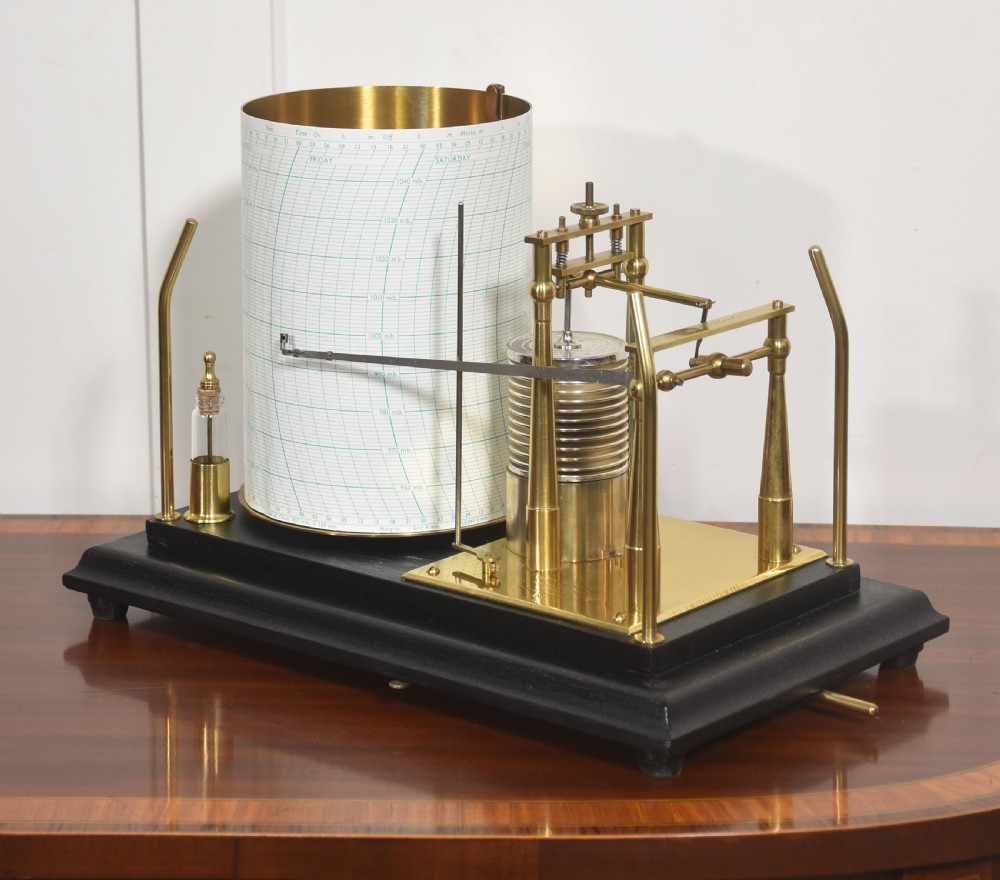 An antique Short and Mason aneroid barograph housed in a black glazed wooden case with brass carrying handles and internal mechanism. View IX