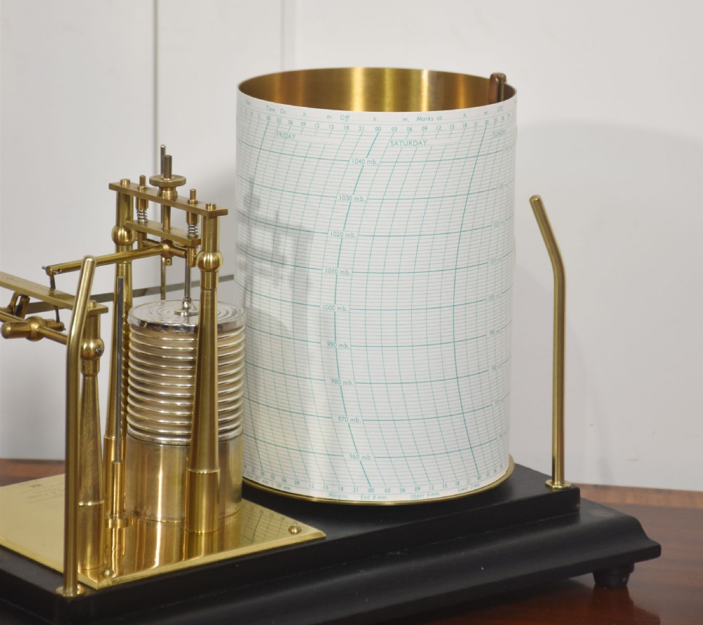 An antique Short and Mason aneroid barograph housed in a black glazed wooden case with brass carrying handles and internal mechanism. View XI