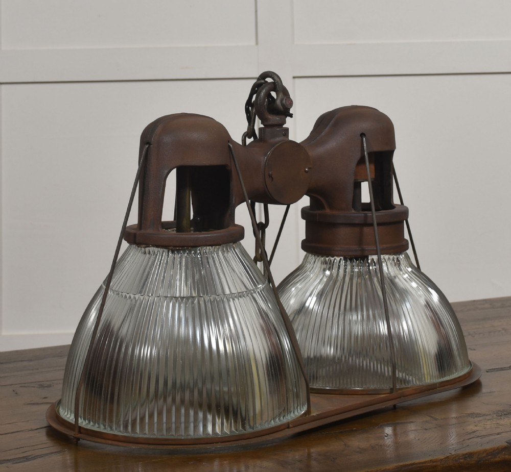 A pair of double-dome industrial pendant lights featuring clear ribbed Holophane glass shades set in dark brown metal frames with chain supports. View II