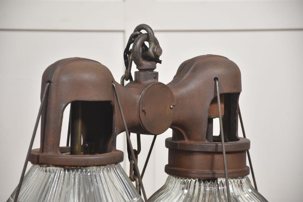 A pair of double-dome industrial pendant lights featuring clear ribbed Holophane glass shades set in dark brown metal frames with chain supports. View III