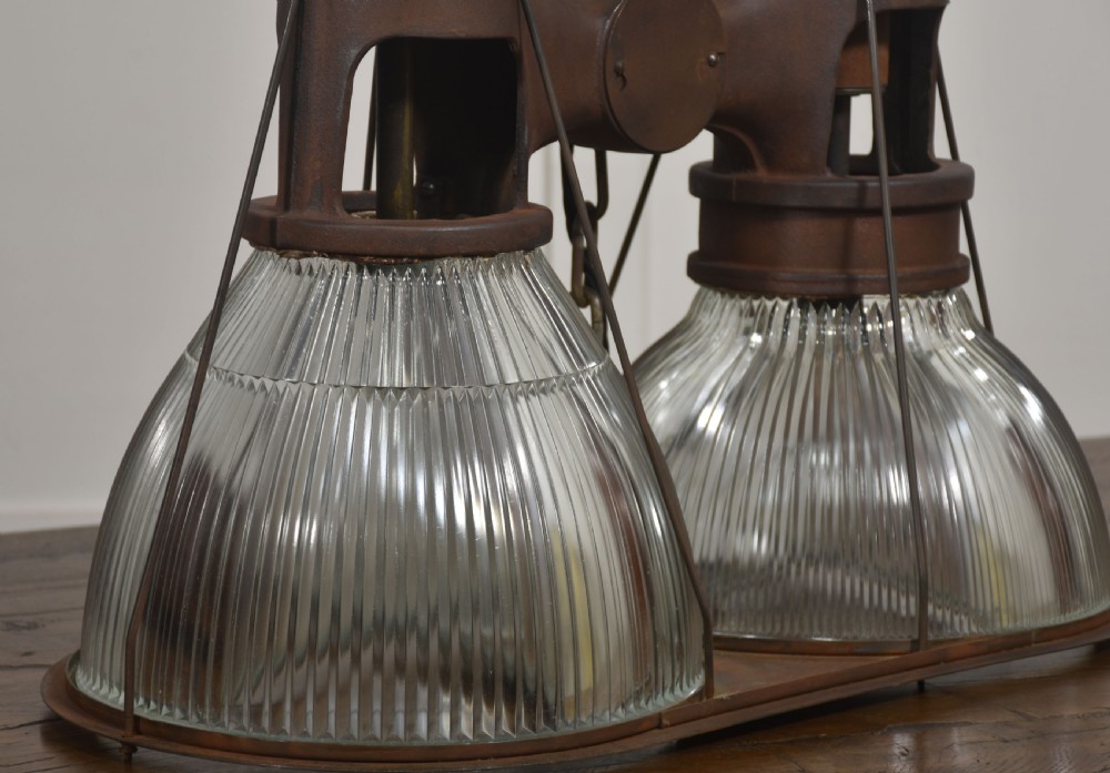 A pair of double-dome industrial pendant lights featuring clear ribbed Holophane glass shades set in dark brown metal frames with chain supports. View IV
