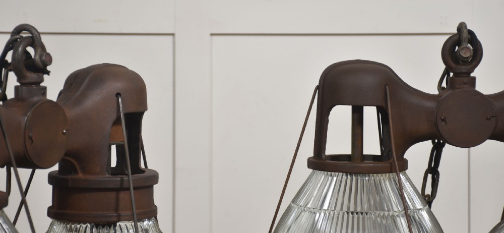 A pair of double-dome industrial pendant lights featuring clear ribbed Holophane glass shades set in dark brown metal frames with chain supports. View VI