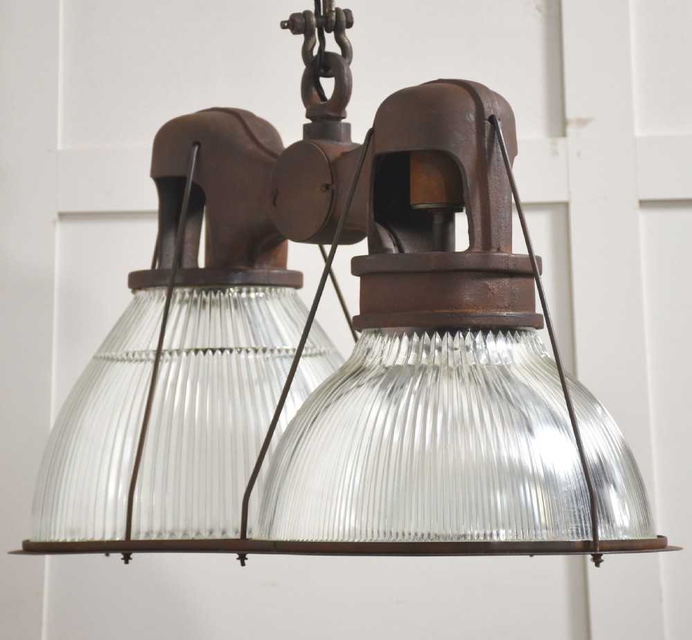 A pair of double-dome industrial pendant lights featuring clear ribbed Holophane glass shades set in dark brown metal frames with chain supports. View IX
