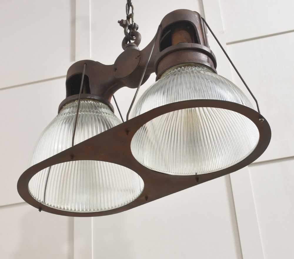 A pair of double-dome industrial pendant lights featuring clear ribbed Holophane glass shades set in dark brown metal frames with chain supports. View XI