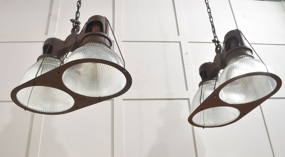 A pair of double-dome industrial pendant lights featuring clear ribbed Holophane glass shades set in dark brown metal frames with chain supports. View XII