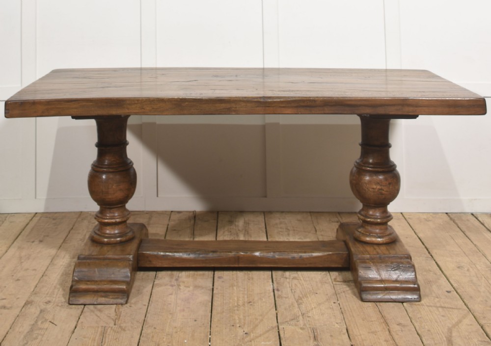 Solid oak refectory dining table featuring thick timber top, bulbous turned baluster pedestals, and a floor stretcher rail. View II