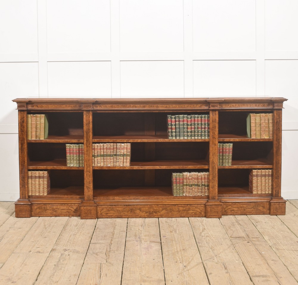 A low three-section breakfront open bookcase made from burr walnut veneer with adjustable shelves and a plinth base. View V