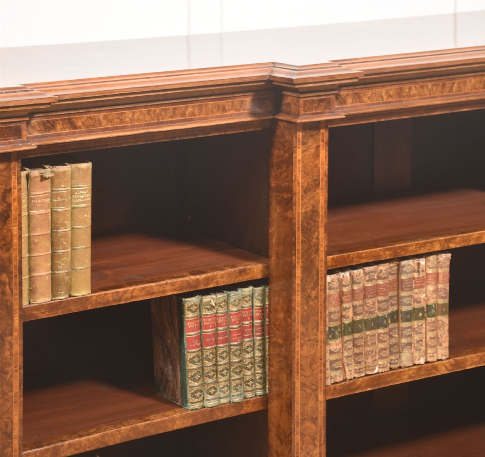 A low three-section breakfront open bookcase made from burr walnut veneer with adjustable shelves and a plinth base. View VII