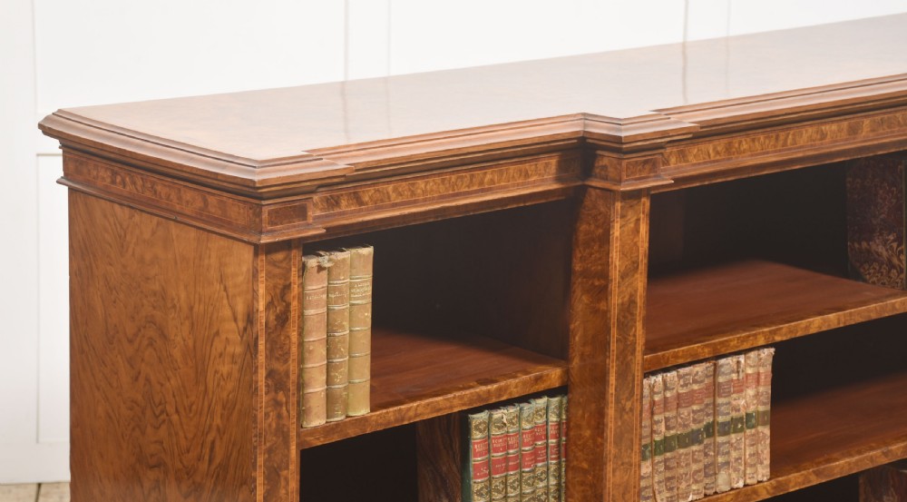 A low three-section breakfront open bookcase made from burr walnut veneer with adjustable shelves and a plinth base. View IX
