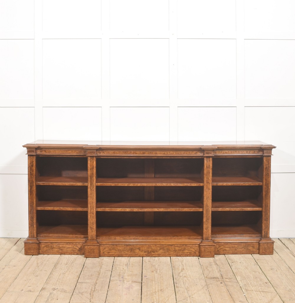 A low three-section breakfront open bookcase made from burr walnut veneer with adjustable shelves and a plinth base. View X