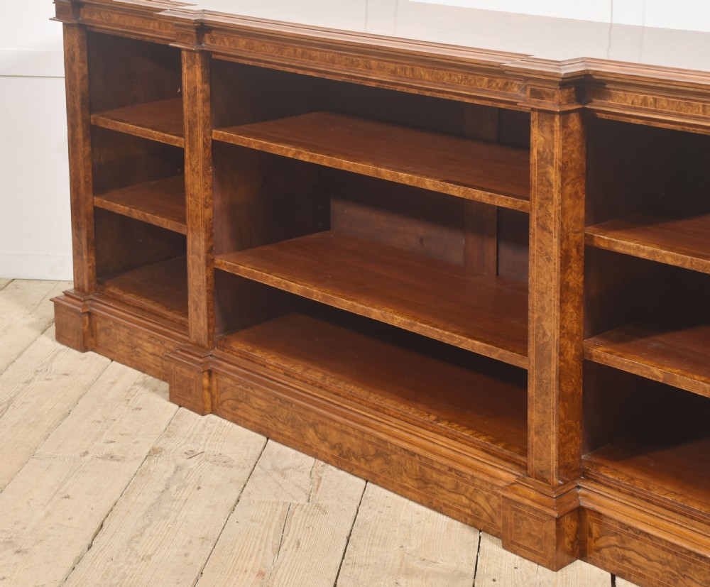 A low three-section breakfront open bookcase made from burr walnut veneer with adjustable shelves and a plinth base. View XVIII
