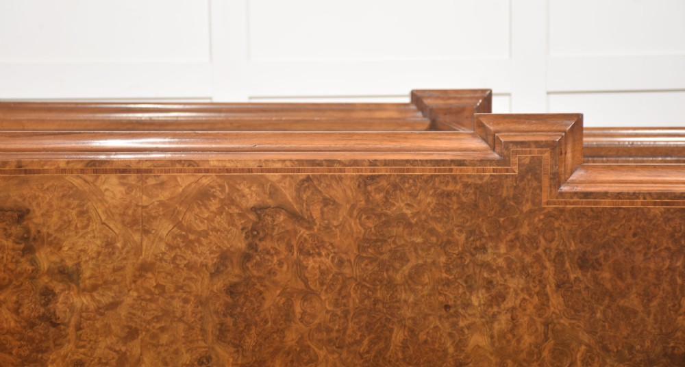 A low three-section breakfront open bookcase made from burr walnut veneer with adjustable shelves and a plinth base. View XX