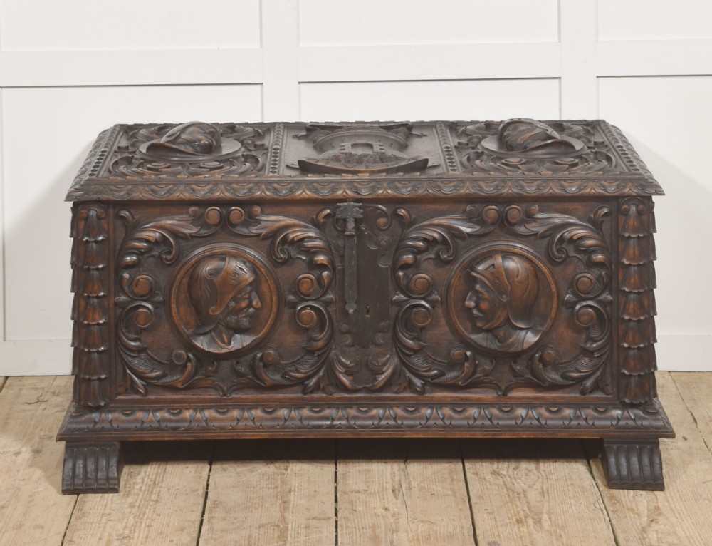 A dark carved walnut coffer featuring two profile portrait medallions surrounded by intricate acanthus foliage carving and a central iron lock plate. View XI