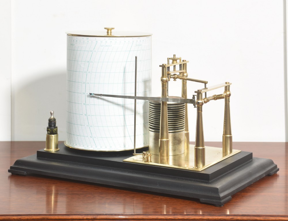 An antique brass-framed glass display case housing a scientific barograph mechanism with a paper chart drum, aneroid capsules, and pen arm. View VIII