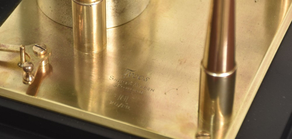 An antique brass-framed glass display case housing a scientific barograph mechanism with a paper chart drum, aneroid capsules, and pen arm. View IX