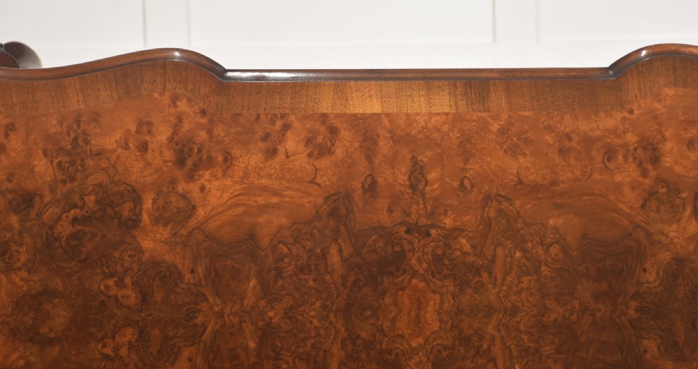 A burr walnut writing table featuring three drawers with brass handles and slender cabriole legs. View XVI