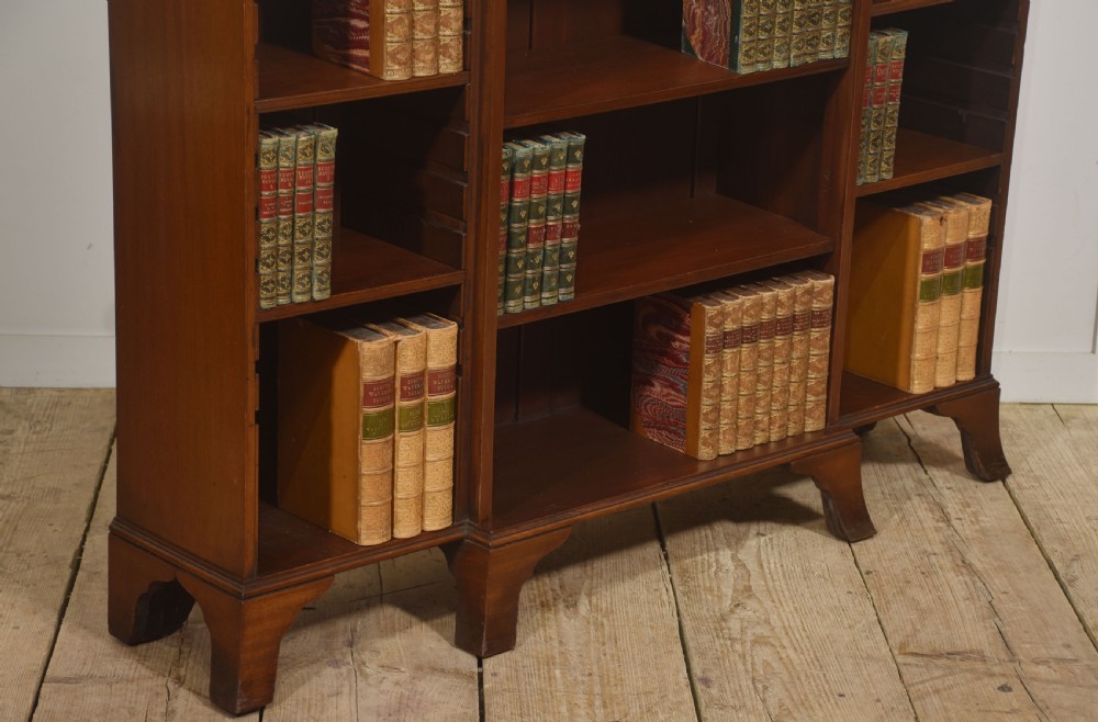 A low mahogany breakfront open bookcase featuring a reeded frieze top, adjustable shelf sections, and bracket feet. View IV