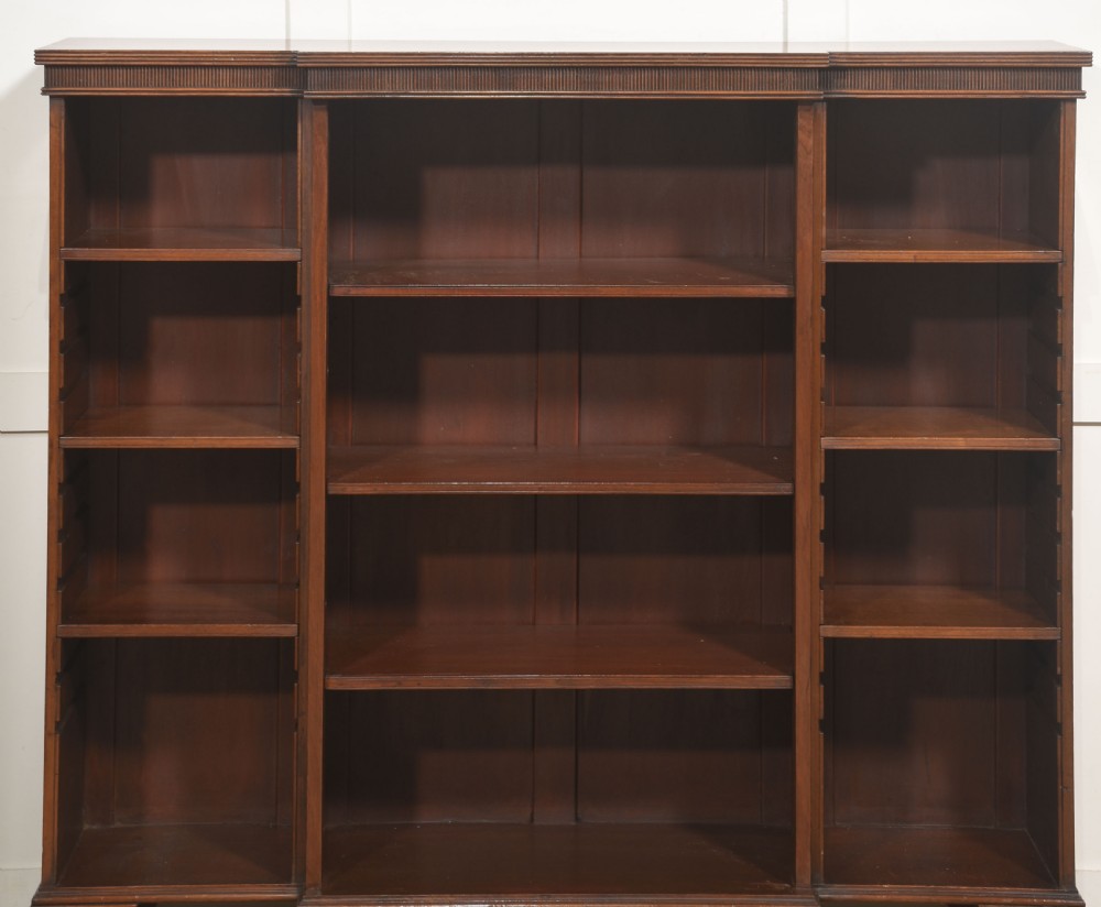 A low mahogany breakfront open bookcase featuring a reeded frieze top, adjustable shelf sections, and bracket feet. View VIII