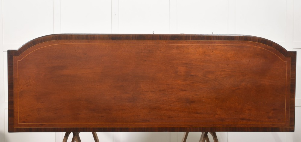 A George III style mahogany bow-front sideboard featuring marquetry urn inlays on twin side cupboards, a central drawer with brass lion mask handles, and reeded tapering legs. View XIV