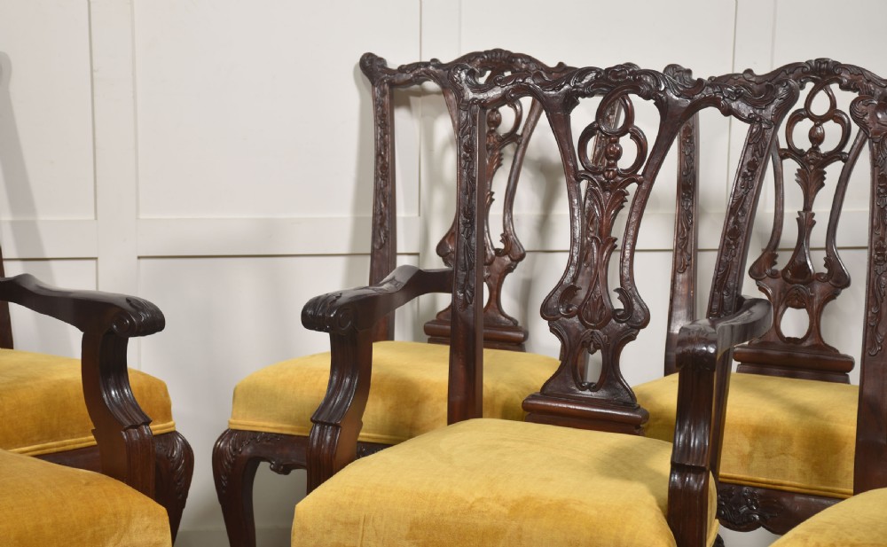 A set of eight dark mahogany dining chairs featuring elaborate pierced back splats, cabriole legs with ball and claw feet, and mustard yellow velvet upholstered seats. View II