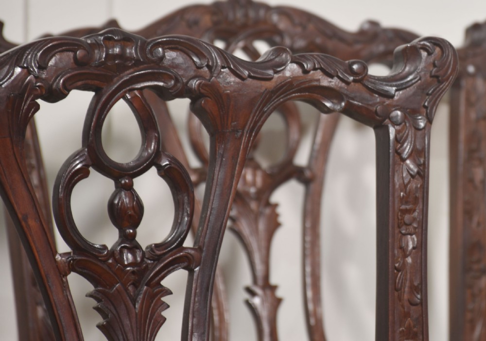 A set of eight dark mahogany dining chairs featuring elaborate pierced back splats, cabriole legs with ball and claw feet, and mustard yellow velvet upholstered seats. View IV